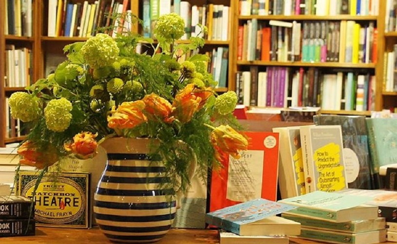 Bouquet of flowers next to piles of books at Topping & Co